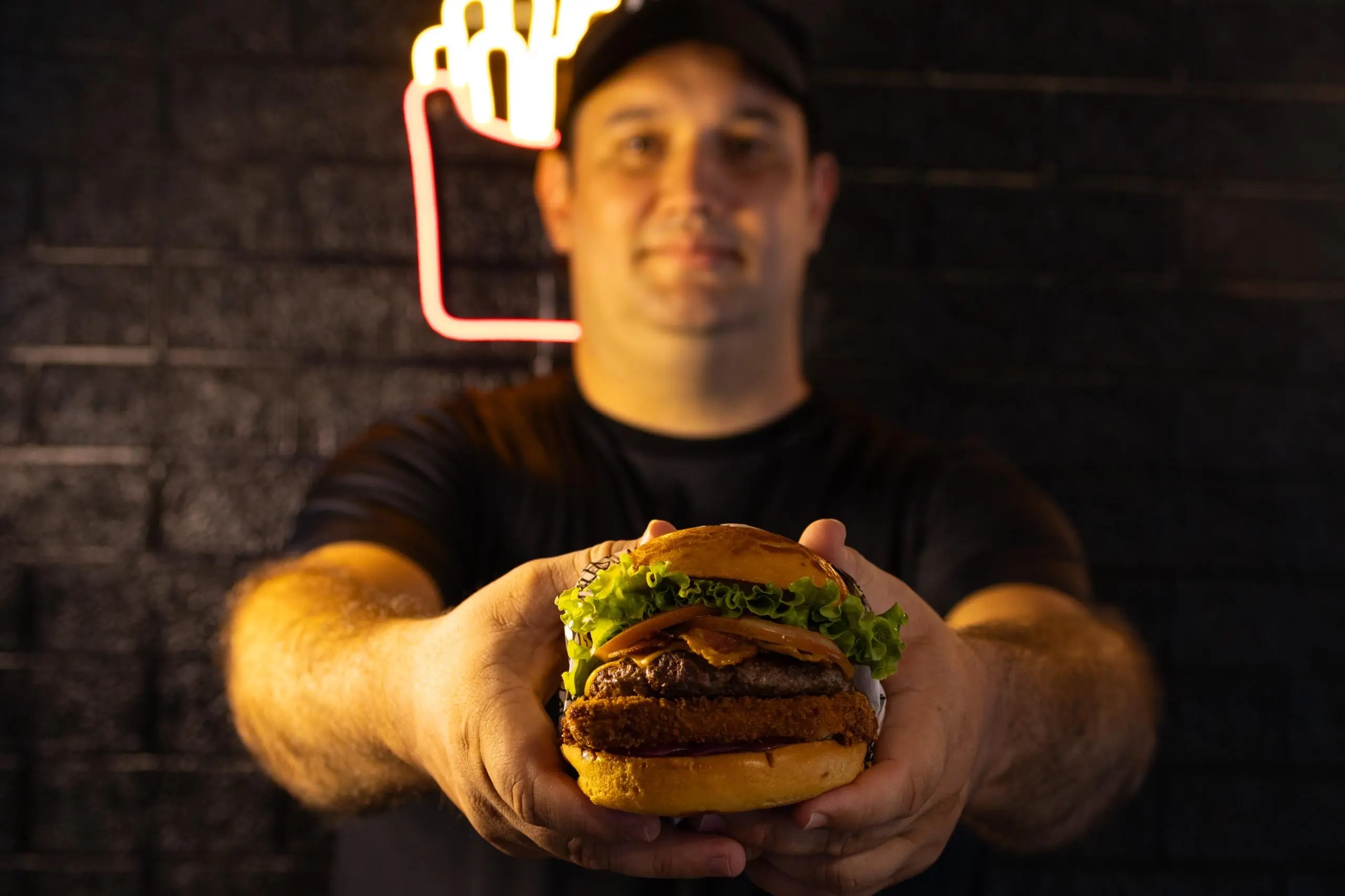 Wagner segurando hambúrguer Fabs Burguer